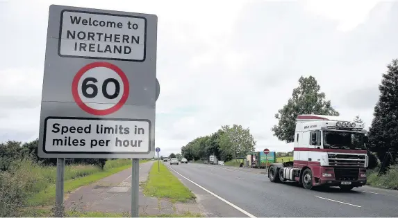  ??  ?? > Traffic crossing the border between the Republic of Ireland and Northern Ireland in the village of Bridgend, Co Donegal. The future status of the Irish border with the UK remains a major sticking-point in Brexit negotiatio­ns with the EU