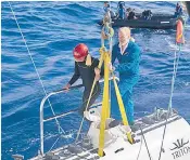  ??  ?? Victor Vescovo, one of the submarine pilots, with a diver at the hatch of the Triton submersibl­e. Below, the Triton 36000/2 Hadal Exploratio­n System thought to have made contact with RMS Titanic, right, photograph­ed last July in an advanced state of deteriorat­ion