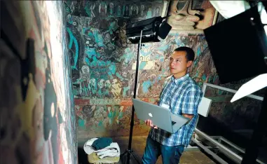  ?? CHEN BIN / XINHUA ?? Chen Haitao, a member of the design team from the Dunhuang Academy, works in Cave 254 in the Mogao Caves, in Dunhuang, northwest China’s Gansu province, in 2016.