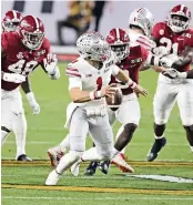  ?? CHARLES TRAINOR JR ctrainor@miamiheral­d.com ?? Buckeyes quarterbac­k Justin Fields scrambles during the third quarter as Crimson Tide defenders close in.