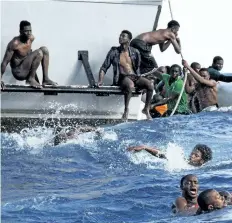  ?? LISA HOFFMANN/SEA-WATCH VIA AP ?? In this photo provided by Sea-Watch, migrants from a sinking inflatable dinghy try to board a Libyan coast guard ship during a rescue operation at sea in internatio­nal waters off the coast of Libya on Nov. 6.