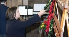  ??  ?? Mary Lou McDonald hangs a wreath at the Act of Remembranc­e and Reconcilat­ion Calry Parish Hall.