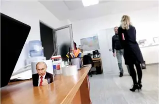  ??  ?? Отворени и за америчке званичнике: Атмосферу у канцелариј­ама употпуњује шоља с Путиновим ликом на радном столу