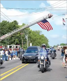  ?? TIMES photograph by Annette Beard ?? The funeral procession­al for slain Pea Ridge Police Officer Kevin Apple stretched for miles along Slack Street and down South Curtis Avenue in Pea Ridge and drew a large crowd. Flags were flown over the street by members of the Pea Ridge Fire-EMS Department.