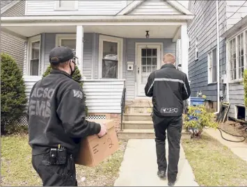  ?? Lori Van Buren / Times Union ?? EMTS and Paramedics James Mudge, left, and David Gallati arrive Friday at Ruth Munro’s home to administer­s a COVID-19 vaccine for her in Albany.