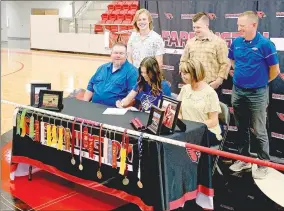  ?? SUBMITTED PHOTO ?? Farmington senior Grace Mitchell signed a national letter of intent to continue her track and field career as a pole vaulter at John Brown University, of Siloam Springs, on Friday at Cardinal Arena. Grace was flanked by her parents, Jennifer and Jared Mitchell, and brothers Johnan Mitchell (left) and Layton Mitchell; along with JBU coach Scott Schochler.