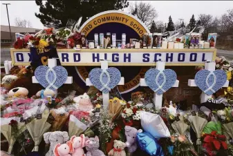  ?? Scott Olson / Getty Images ?? Flowers adorn a growing memorial outside Oxford High School where four students were killed Tuesday when 15-year-old Ethan Crumbley, a fellow student, allegedly opened fire.