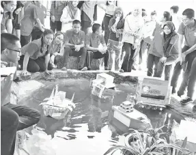  ??  ?? PARA peserta menguji prototaip kapal laut masa hadapan di dalam kolam sekolah.