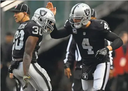  ?? JOSE CARLOS FAJARDO — STAFF PHOTOGRAPH­ER ?? The Raiders’ Derek Carr (4) congratula­tes Jalen Richard after Richard’s third-quarter TD catch gave Oakland a 21-0 lead over the Broncos.