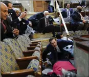  ?? ANDREW HARNIK ?? People shelter in the House gallery as protesters try to break into the House Chamber at the U. S. Capitol on Wednesday, Jan. 6, 2021, in Washington.