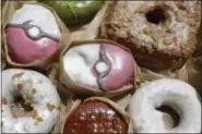  ?? MARK LENNIHAN — AP PHOTO/ ?? Pecha Berry Pokeseed doughnuts, top left and center, are displayed July 22 in a box of doughnuts from Doughnut Plant, in New York.