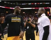  ?? DAVID SANTIAGO/TNS ?? LeBron James chats with good friend Dwyane Wade during halftime of Miami’s blowout win on Saturday. Cavs coach Tyronn Lue wasn’t impressed with the friendly gesture.