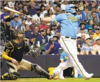  ?? MORRY GASH AP ?? Milwaukee’s Rowdy Tellez hits a three-run home run during the third inning as Padres catcher Gary Sánchez watches.