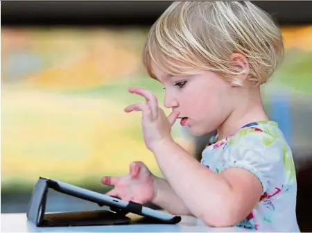  ?? — AFP ?? A child using a tablet with touchscree­n.