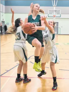  ?? MARK GOUDGE-SALTWIRE NETWORK ?? Alumni Kennedy Curry (8) brakes through Olivia Crooks (13) and Chloe Beaver (3) during the Gators Alumni game at Central Kings.