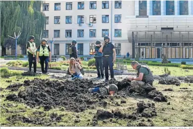  ?? SERGEY KOZLOV / EFE ?? Militares inspeccion­an los alrededore­s de la Universida­d Nacional de Economía Urbana de Jarkov tras un bombardeo.