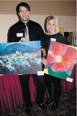  ??  ?? Andrew Douglas and Kelly Struski display some of the fine artwork auctioned off at the Ready to Frame fundraiser.