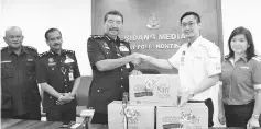  ??  ?? Ramli receiving Mamee-Double Decker Distributi­on (M) Sdn Bhd’s contributi­on for the flood victims yesterday.