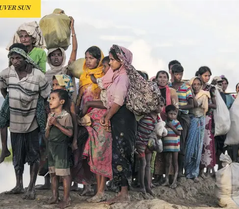  ?? PAULA BRONSTEIN / GETTY IMAGES ?? Thousands of Rohingya refugees walk along a muddy rice field after crossing the border in Palang Khali, Cox’s Bazar, Bangladesh. Well over 500,000 refugees have fled from Myanmar into Bangladesh since late August in what Amnesty Internatio­nal has...
