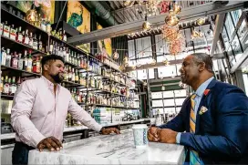  ?? JENNI GIRTMAN FOR THE AJC / 2022 FILE ?? Investor Armond Davis (right), managing partner of The Paragon Group, and “A Seat at The Table Capital” owner Camaran Burke catch up at Holiday Bar in West Midtown, one of Burke’s four bars in Atlanta. Davis works with black-owned businesses to fill the gap many African Americans face when seeking financing.