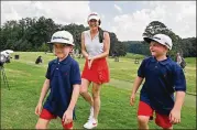  ??  ?? Ashley Siller smiles after she posed with sons Banks, 5 (left), and Beau, 7, for photograph­ers. She said that while nothing can be done to change what happened, “what we can do is remember Gene and his legacy and all the humble and amazing things that he stood for.”