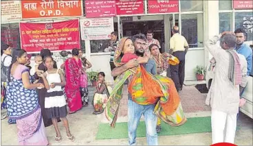 ??  ?? Abdul Hamid carrying his injured wife in Lohia Hospital as he could not arrange a wheelchair due to lack of ID proof.