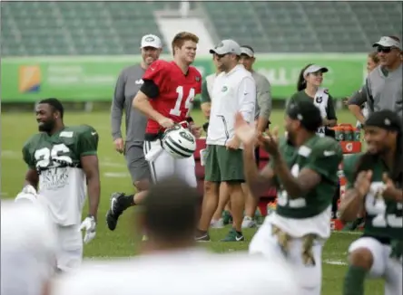  ?? SETH WENIG - THE ASSOCIATED PRESS ?? Teammates clap as Sam Darnold (14) arrives for NFL football training camp practice in Florham Park, N.J., Monday, July 30, 2018. The Jets signed Darnold to a four-year, $30.25million deal, ending the rookie quarterbac­k’s contract holdout.
