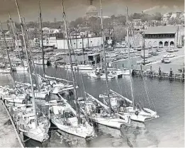  ?? CAROL SWAN ?? Oyster skipjacks and patent tongers crowd City Dock with a tonger unloading to a truck in 1968 — a common winter sight the author saw but will never see again, he says, due to the oyster collapse.
