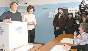  ?? — AFP ?? Prime Minister Matteo Renzi and his wife Agnese Landini cast their votes on Sunday at a polling station in Florence.