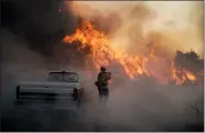  ?? JAE C. HONG — THE ASSOCIATED PRESS ?? Firefighte­r Raymond Vasquez battles the Silverado Fire on Monday in Irvine, Calif.