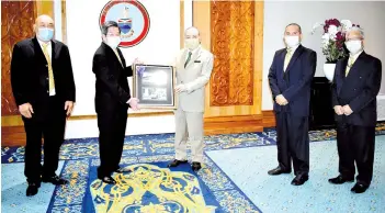  ??  ?? Gan (left) presenting Hajiji with a memento after the courtesy call. Also present are RASA secretary general Effendi Sunoh, treasurer Rahim Kahar and media coordinato­r Salim Ibrahim.