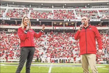  ?? UGa Sports Communicat­ions — Mackenzie Miles ?? New Georgia basketball coaches Katie Abrahamson-Henderson and Mike White take the field before last weekend’s G-Day football scrimmage last weekend.