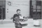  ??  ?? Volunteer Amru Ashour carries sack lunches to a car Saturday. The lunches – as well as coffee and gently used winter clothing – were to be delivered to the homeless at five Denver-area locations.