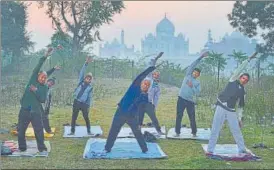  ?? PTI ?? Elderly persons do yoga with the Taj Mahal in the backdrop, in Agra on Saturday morning.