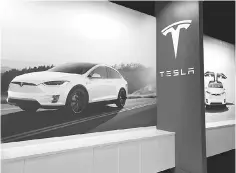  ??  ?? This file photo shows posters showing the Tesla Model X displayed at a Tesla showroom in Corte Madera, California. Tesla Inc said it would raise about US$1.5 billion through its first-ever offering of junk bonds as the US luxury electric car maker...