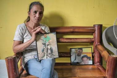  ??  ?? CATHY Nuñez, mother of UNTV reporter Victor Nuñez, holds the portrait of her son in their residence somewhere in Mindanao. Nuñez has been receiving death threats and welcomes the decision of the court convicting 28 people involved in the Ampatuan Massacre. “I thank God for hearing our prayers,” she said after the verdict was handed down in Taguig. MindaNews photo by FROILAN GALLARDO