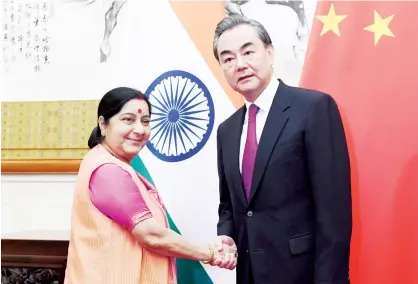  ?? Agence France-presse ?? Sushma Swaraj greets Wang Yi at the Diaoyutai State Guest House in Beijing on Sunday. BEIJING: