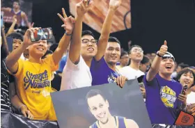  ?? Zhong Zhi / Getty Images 2016 ?? Klay Thompson plays pingpong with children at the NBA Cares Reading and Learning Center at a school in Beijing in 2013. Fans cheer for Stephen Curry during the Warriors star guard’s appearance at an event at Asian Games Stadium in Guangzhou, China, in...