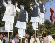  ?? — PTI ?? Congress Party workers hold Madhya Pradesh Congress leader Jyotiradti­tya Scindia’s cutout as they celebrate at the Congress headquarte­rs in Bhopal on Tuesday.