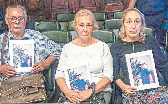  ?? Télam ?? Los padres y la hermana de Osvaldo Ciarallo, cada uno con una foto de la víctima, durante el juicio