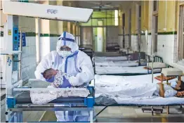  ?? — PTI ?? A resident doctor wearing PPE kit does a check-up of a new born baby in an isolation ward at the Nowrosjee Wadia Maternity Hospital in Mumbai.