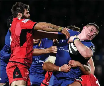  ??  ?? Tadhg Furlong in the thick of the action for Leinster as he is tackled by Edinburgh’s Cornell du Preez and Darryl Marfo during the Guinness PRO14 match in the RDS Arena on Friday. Leinster won 21-13.