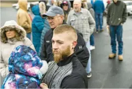  ?? MICHAEL SWENSEN/GETTY ?? Neil Figley holds his daughter Harlie as they wait in line Friday in East Palestine, Ohio. Figley and others were waiting to collect reimbursem­ent checks for expenses they incurred after they evacuated from the area surroundin­g a train derailment Feb. 3.