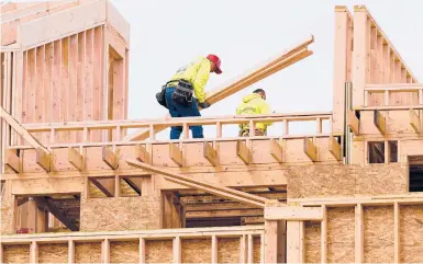  ?? MATT ROURKE/AP ?? Workers build homes in Philadelph­ia April 5. Rates on home loans have soared this year and are expected to rise further.