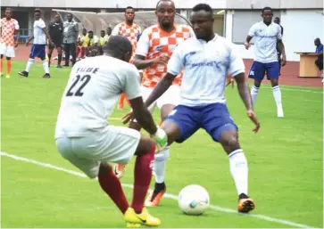  ??  ?? Rivers United’s Emekayi Temple shields the ball away from Akwa United player for his team mate and goalkeeper, Egbe Ospino to pick during a recent league clash