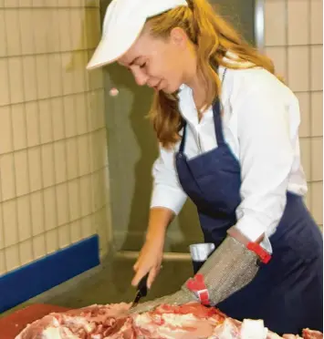  ?? Foto: Carmen Schwab ?? Mit einem speziellen Schutzhand­schuh darf Carmen Schwab versuchen, ein Stück Fleisch abzutrenne­n. Bald muss sie aufgeben. Das ist etwas für Fachleute, wie die Erfahrung in der Metzgerei in Bobingen zeigt.