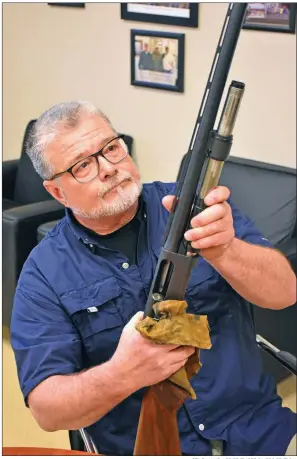  ?? STACI VANDAGRIFF/THREE RIVERS EDITION ?? Mark Wyatt, the new shooting-range manager for the Paul H. “Rocky”Willmuth Shooting Sports Complex in Batesville, examines one of the shotguns used for shooting at the complex. Wyatt started his new job as shooting-range manager Jan. 1.