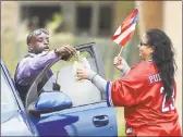  ?? Catherine Avalone / Hearst Connecticu­t Media ?? A motorist on Front Street in New Haven gives a donation to Elizabeth Reyes, of New Haven, to support relief for Puerto Rico.