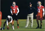  ?? PATRICK TEHAN — BAY AREA NEWS GROUP FILE ?? San Francisco 49ers starting quarterbac­k Colin Kaepernick (7) runs a passing drill as head coach Jim Harbaugh and quarterbac­k Alex Smith (11) look on during practice at the 49ers training facility in Santa Clara on Jan. 25, 2013.