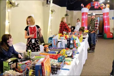  ?? ?? Volunteers — young and old — worked providing gifts for hundreds of children who would not have otherwise had any at The Ridge Church gift giveaway.